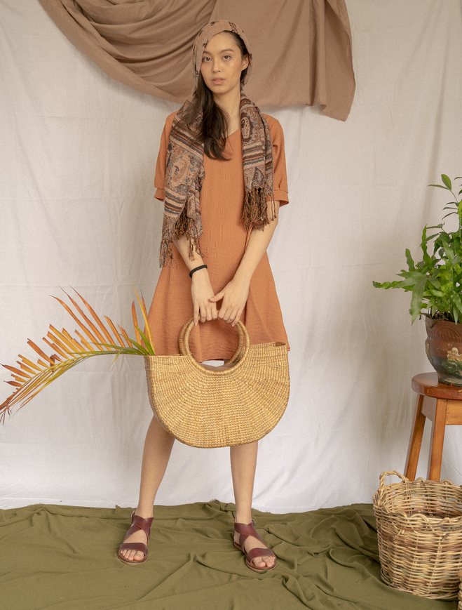 Woman with Headscarf Holding a Wicker Bag with Palm Leaf